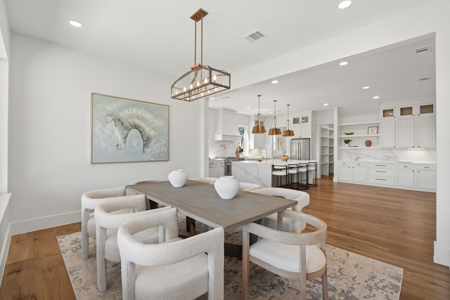 dining room with an inviting chandelier, visible vents, wood finished floors, and recessed lighting