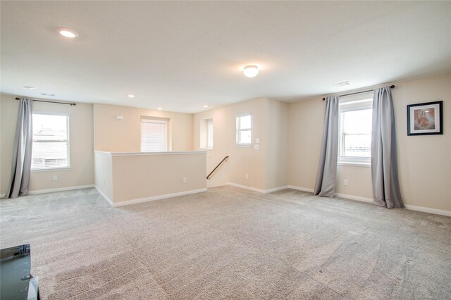 carpeted spare room featuring a healthy amount of sunlight