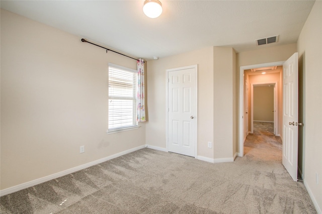 unfurnished bedroom with a closet and light carpet