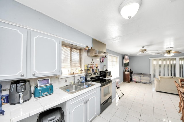 kitchen with tile countertops, ventilation hood, white cabinetry, sink, and stainless steel appliances