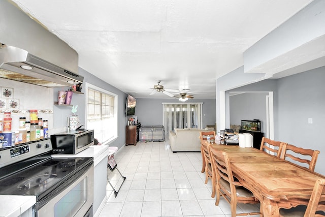 kitchen featuring light tile patterned flooring, ceiling fan, stainless steel appliances, and exhaust hood