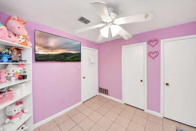 unfurnished bedroom with ceiling fan and light tile patterned floors