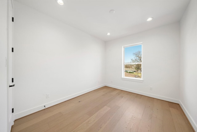 empty room with recessed lighting, light wood-style flooring, and baseboards