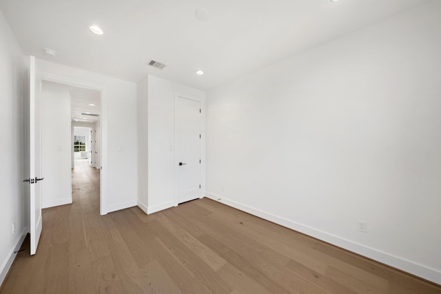 unfurnished bedroom featuring baseboards, visible vents, wood finished floors, and recessed lighting