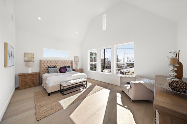 bedroom with light hardwood / wood-style flooring and high vaulted ceiling