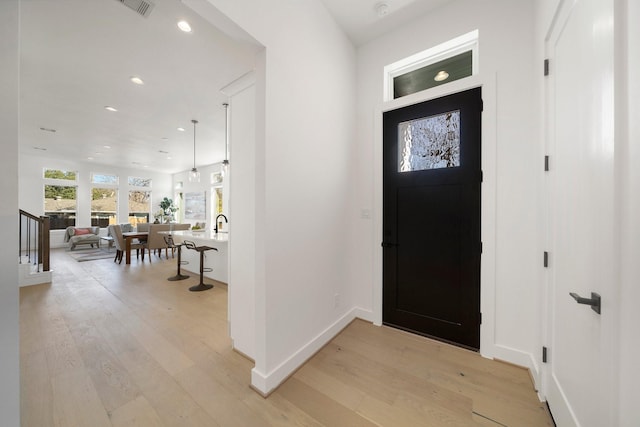 foyer with recessed lighting, visible vents, baseboards, stairway, and light wood finished floors