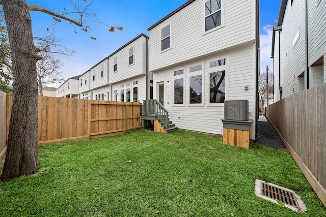 back of house featuring a fenced backyard and a yard