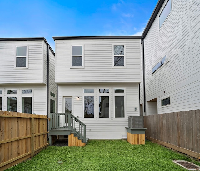 back of property featuring a lawn and a fenced backyard