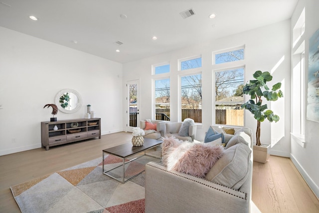 living room with baseboards, visible vents, wood finished floors, and recessed lighting