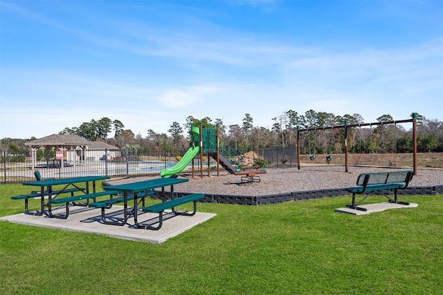 community jungle gym with a gazebo, a lawn, and fence