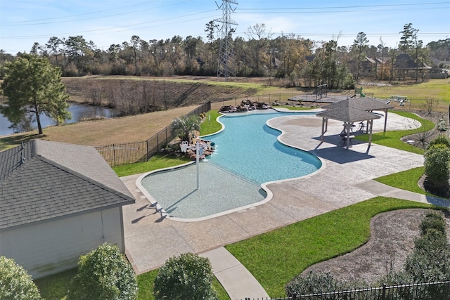 view of swimming pool featuring a patio, a lawn, and fence