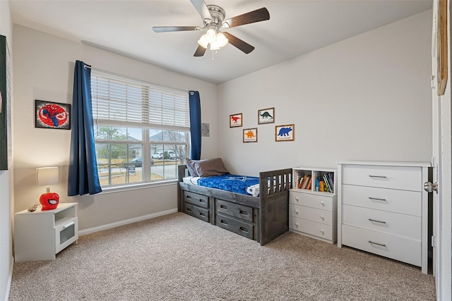 carpeted bedroom with ceiling fan and baseboards