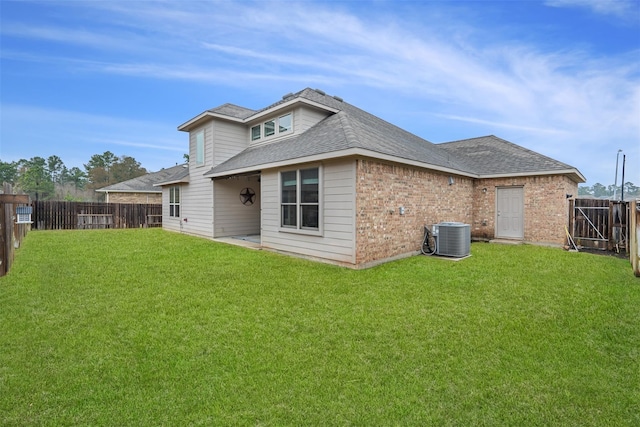 back of property featuring central air condition unit, a fenced backyard, a yard, a shingled roof, and brick siding