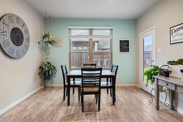 dining area with light wood-type flooring and baseboards