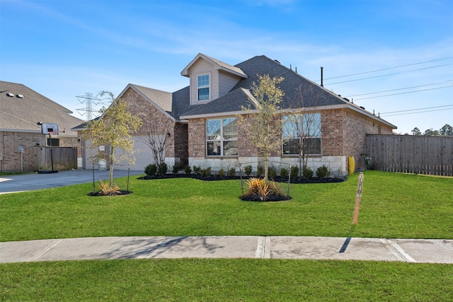 view of front of home featuring an attached garage, fence, brick siding, and driveway