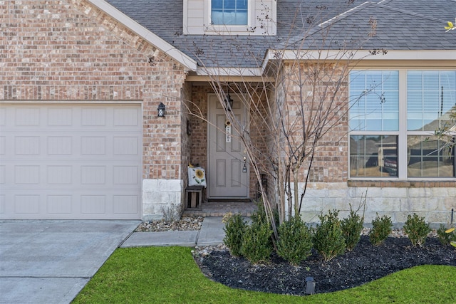 property entrance featuring an attached garage, stone siding, a shingled roof, and brick siding