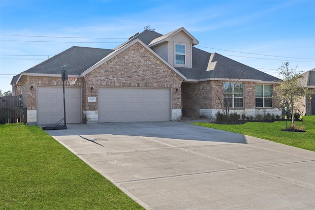 view of front of house with a shingled roof, brick siding, and a front lawn