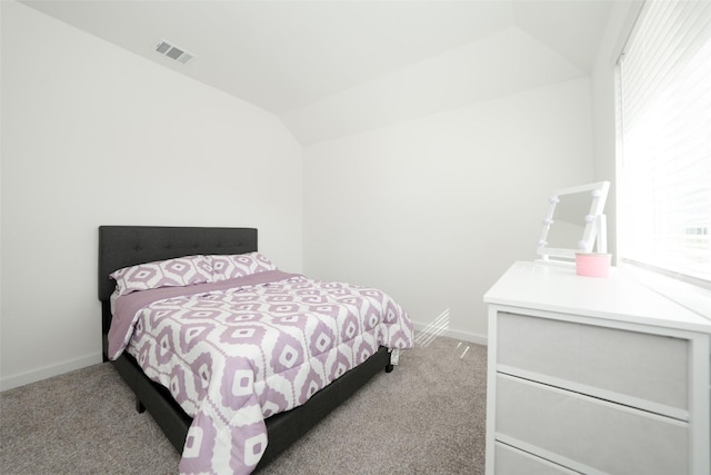 bedroom featuring light colored carpet and vaulted ceiling