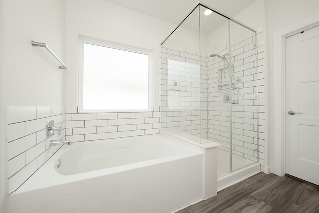 bathroom with hardwood / wood-style flooring and independent shower and bath