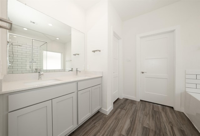 bathroom featuring wood-type flooring, vanity, and a shower with shower door