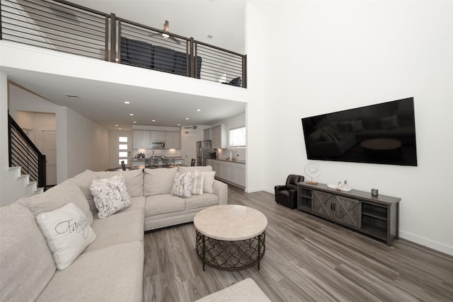 living room with wood-type flooring and a high ceiling