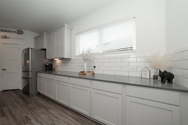 kitchen featuring tasteful backsplash, white cabinetry, dark wood-type flooring, and stainless steel fridge