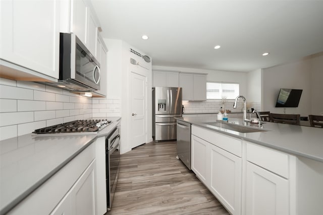 kitchen with appliances with stainless steel finishes, sink, and white cabinets