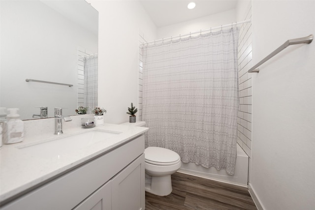 full bathroom featuring vanity, hardwood / wood-style floors, shower / tub combo, and toilet