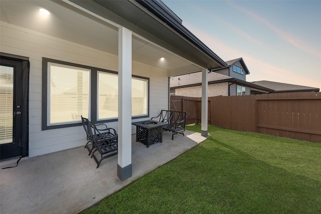 yard at dusk featuring a patio area and a fire pit