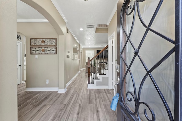 foyer with crown molding and wood-type flooring