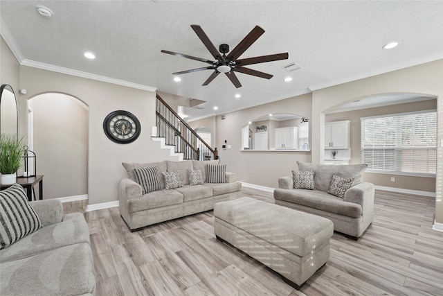 living room featuring ornamental molding, a textured ceiling, and light wood-type flooring