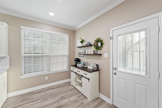 entryway with crown molding and light hardwood / wood-style floors