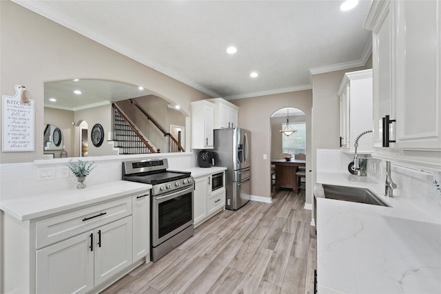 kitchen with sink, crown molding, light hardwood / wood-style flooring, stainless steel appliances, and white cabinets