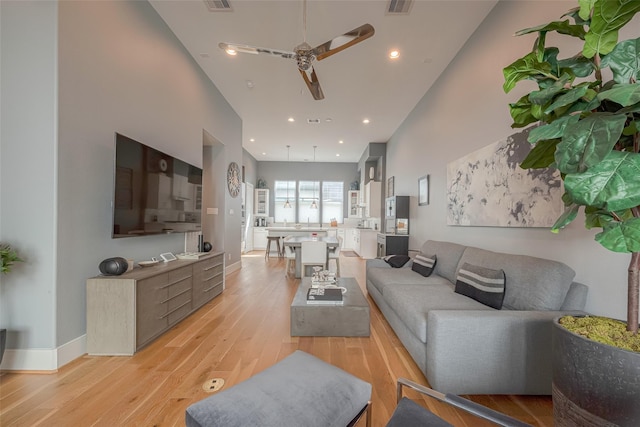 living room featuring ceiling fan and light hardwood / wood-style floors