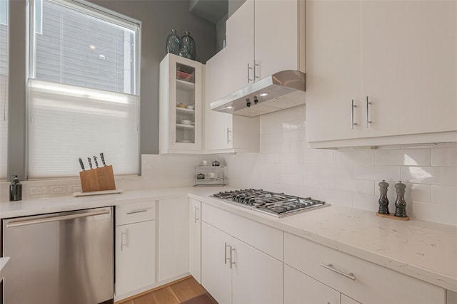 kitchen with appliances with stainless steel finishes, white cabinets, and decorative backsplash