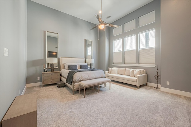 carpeted bedroom featuring a high ceiling and ceiling fan