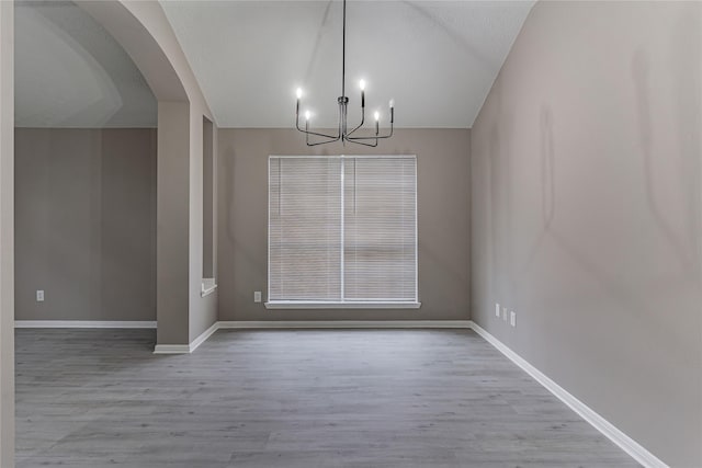 unfurnished dining area with an inviting chandelier and light hardwood / wood-style floors