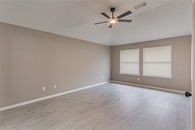 empty room featuring ceiling fan, light hardwood / wood-style flooring, a textured ceiling, and vaulted ceiling