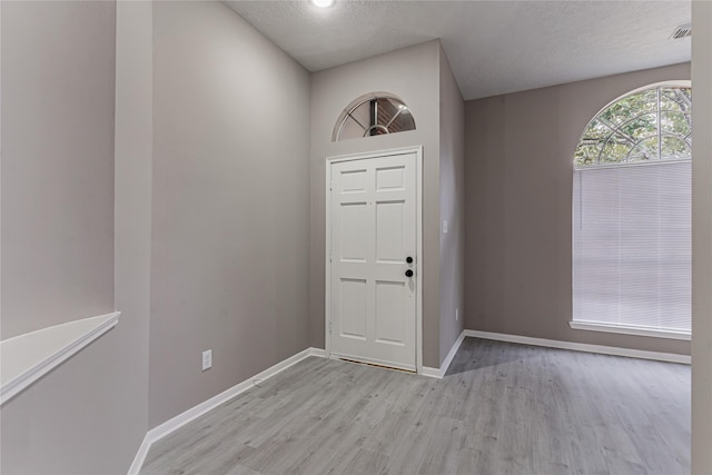 foyer featuring a textured ceiling and light wood-type flooring