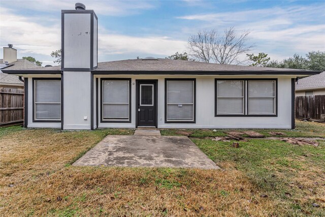 back of property with a patio area and a lawn