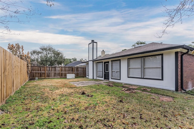 rear view of house featuring a yard and a patio