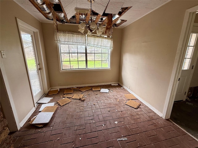 unfurnished dining area featuring brick floor and baseboards