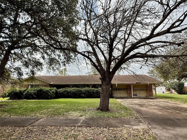 single story home featuring a garage, a front yard, concrete driveway, and brick siding