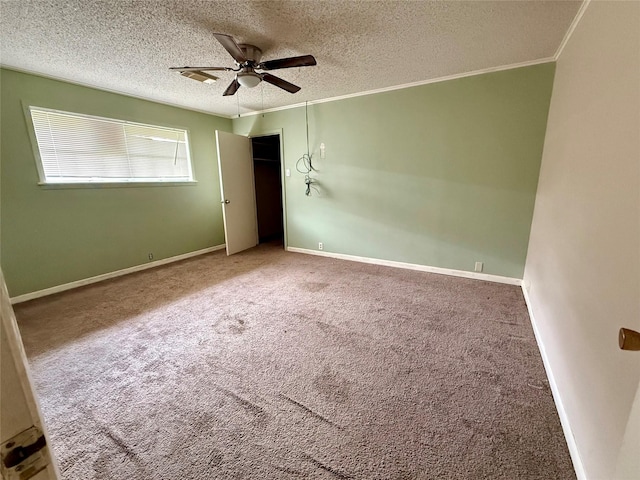 unfurnished bedroom featuring crown molding, a textured ceiling, baseboards, and carpet flooring