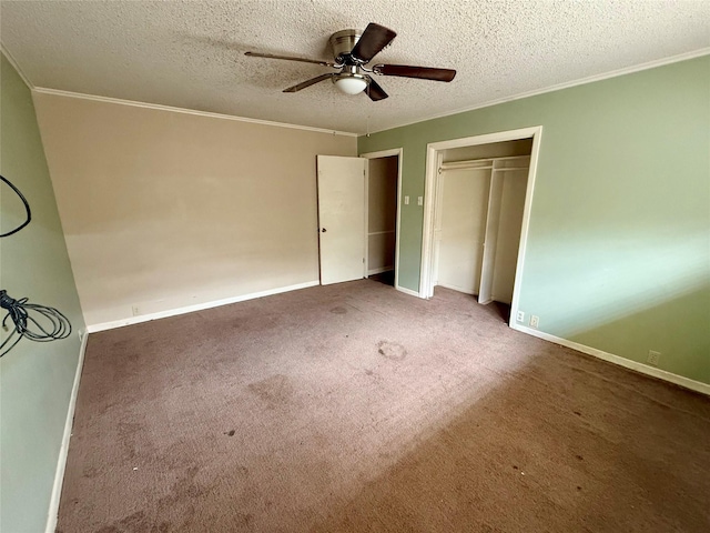 unfurnished bedroom featuring carpet floors, crown molding, a textured ceiling, and baseboards