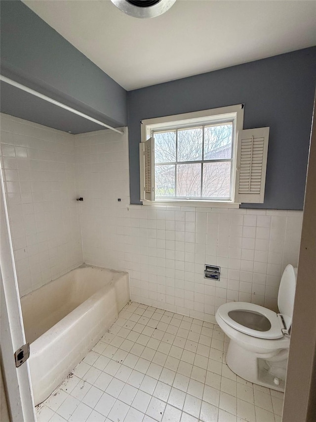 full bath featuring shower / washtub combination, a wainscoted wall, tile walls, toilet, and tile patterned flooring