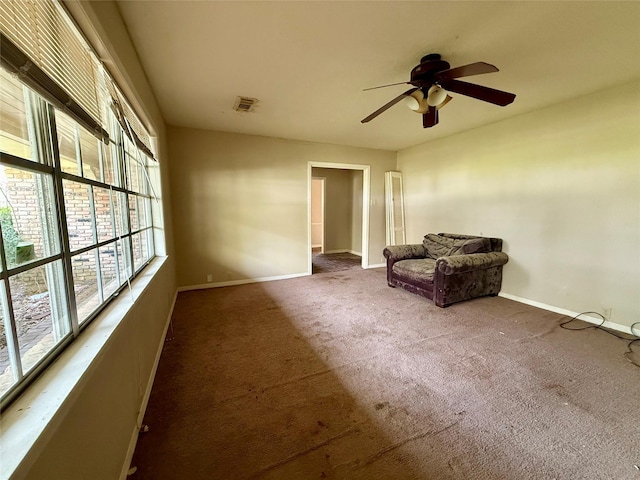 unfurnished room with carpet, visible vents, ceiling fan, and baseboards