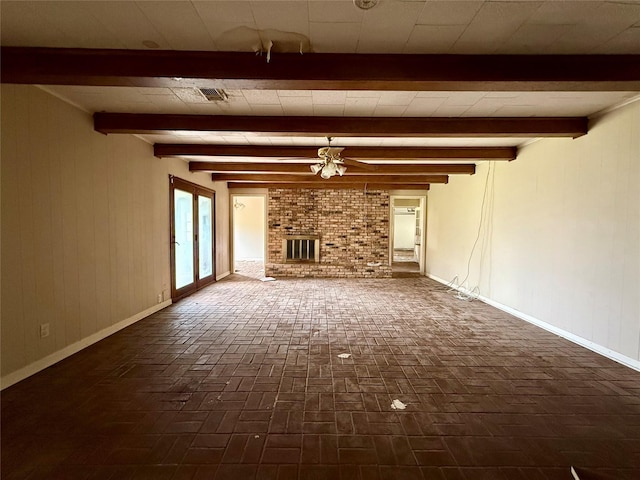 unfurnished living room with a brick fireplace, baseboards, brick floor, and beam ceiling