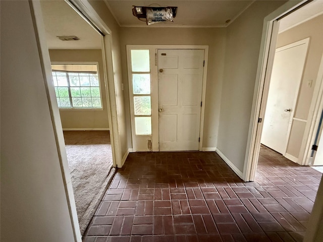 entrance foyer featuring brick floor and baseboards