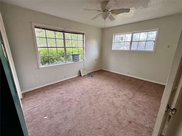 carpeted spare room featuring a healthy amount of sunlight, ceiling fan, a textured ceiling, and baseboards